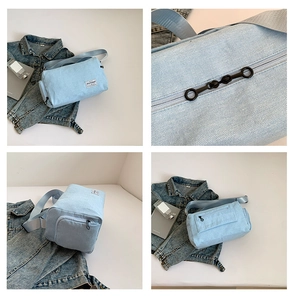 Detail view of light blue canvas cylinder bag with black ring zipper and woven strap