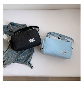 Close-up of cylindrical canvas bags in black and blue with adjustable shoulder straps