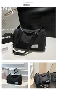 Detail of a black canvas cylindrical crossbody bag featuring an adjustable strap and logo