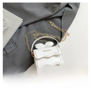 Gros plan du sac bandoulière blanc en cuir PU avec décoration nœud et chaîne dorée