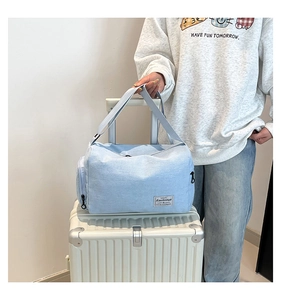 Light blue canvas bag on white suitcase showing large capacity and shoe compartment