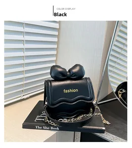 Détail d'un mini sac noir avec nœud 3D, bordure ondulée et logo fashion doré chic
