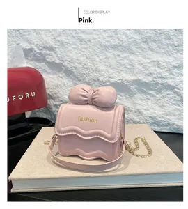 Vue détaillée du mini sac rose avec un grand nœud et des bordures festonnées