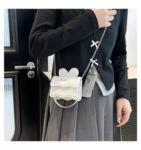 Gros plan sur un mini sac bandoulière blanc avec volants étagés et détails de nœuds