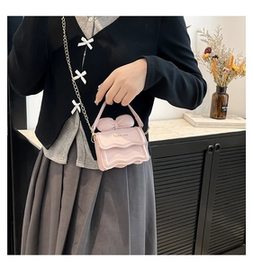 Détail du mini sac à main rose avec nœud surdimensionné et inscription dorée
