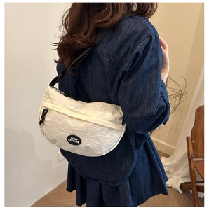 Detailed look at the off-white crescent crossbody bag with adjustable wide strap on model