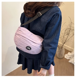 Back view of a lavender nylon crescent crossbody bag with an adjustable black strap