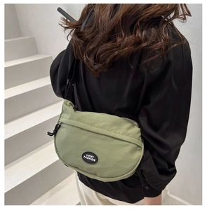 Close-up of green nylon crescent crossbody bag with adjustable strap and Lucky Fashion logo