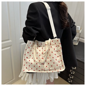 Model wearing off-white corduroy tote bag with red heart embroidery and large capacity