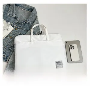 Flat lay of white nylon laptop bag with waterproof finish and dual handles for 14-inch device