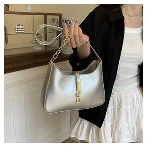 Detailed view of silver metallic leather hobo bag with gold piston lock and chain detail