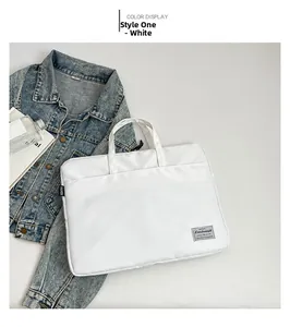 Detailed view of a white minimalist laptop bag with brand woven label on soft background