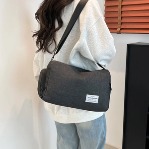 Minimalist dark grey canvas messenger bag with adjustable strap shown from back view