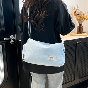 Light blue minimalist canvas crossbody bag for women shown in a casual lifestyle setting
