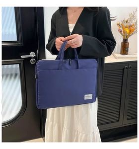 Detail of navy blue student handbag with durable fabric handle and front zipper pocket