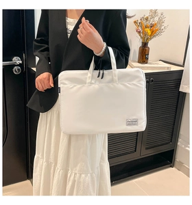 Detailed view of white minimalist laptop bag with dual zippers and durable fabric texture