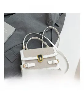 Detail of contrast stitch woven texture with gold twist lock and white leather trim