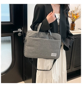 Detail of grey fabric laptop bag with zipper pocket and adjustable shoulder strap