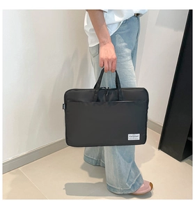 Close-up of black nylon business laptop bag with durable dual handles and front pocket