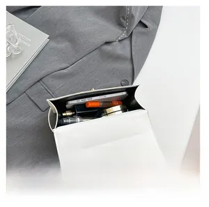 Interior view showing the storage capacity for phone, perfume and lipstick in the white bag