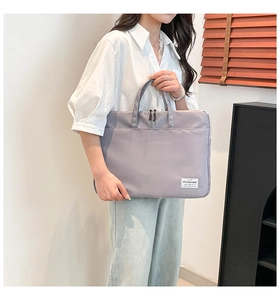 Detail of lavender nylon laptop sleeve featuring a dual zipper and front storage pocket