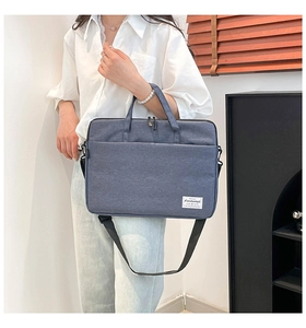 Detail view of the deep blue laptop bag with dual handles and adjustable shoulder strap