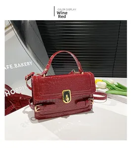 Close-up of wine red crocodile pattern handbag with vintage gold rotary lock closure
