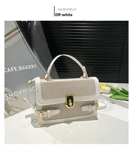 Close-up of cream woven handbag with leather trim and gold metallic lock detail
