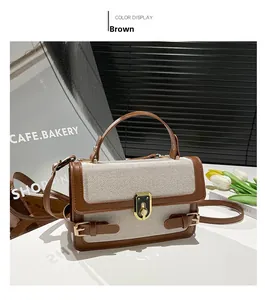 Detail of a retro canvas and brown leather crossbody bag with a golden twist lock closure