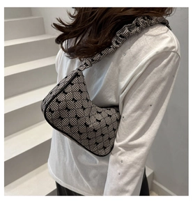 Detail of checkered shoulder bag featuring black bow prints and ruffled ruched strap