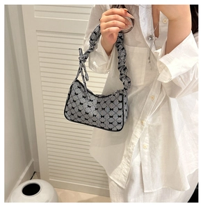 Detail of checkered fabric texture and black bow accents on a trendy underarm bag