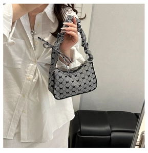 Close-up of black and white gingham bag with bow prints and scrunchie handles
