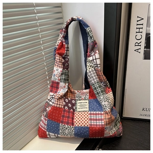 Detailed view of patchwork tote bag with plaid patterns and corduroy fabric texture