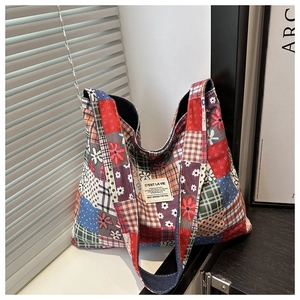 Detailed view of floral and plaid patchwork fabric on a large capacity tote bag