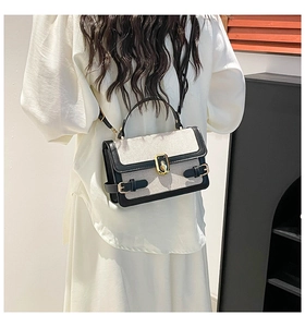 Detail of the chic color-block handbag with fabric texture and gold metal twist lock