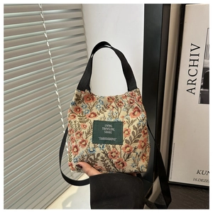 Macro view of vintage floral tapestry fabric and dark green label on mini tote bag