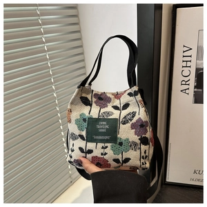 Detailed macro view of the floral jacquard fabric and green woven label on the bucket bag