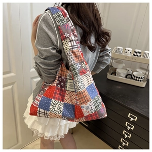 Detailed view of a vintage patchwork tote bag with floral patterns on a female model