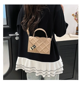 Close-up of quilted beige crossbody bag with gold-tone hardware and chain detail
