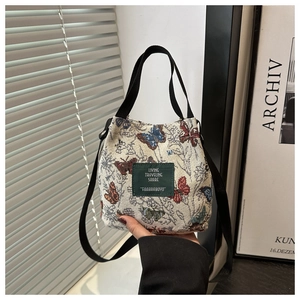 Detailed shot of floral bucket bag with colorful butterfly embroidery and leather patch