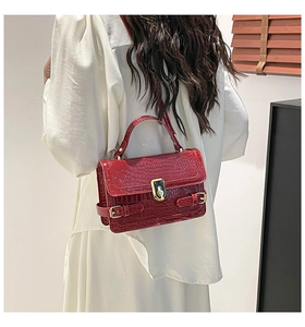 Red crocodile pattern handbag featuring gold twist lock and glossy patent finish