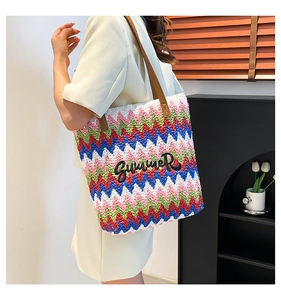 Detail of colorful zigzag woven straw tote with Summer embroidery and leather handles
