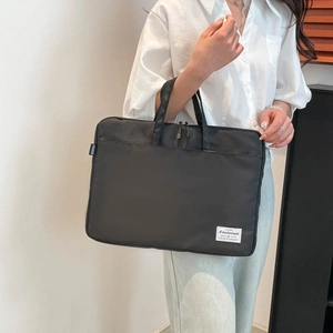 Minimalist black waterproof nylon laptop briefcase shown with dual handles by a model