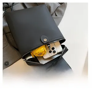 Spacious black backpack interior showing capacity with umbrella, phone and notebook