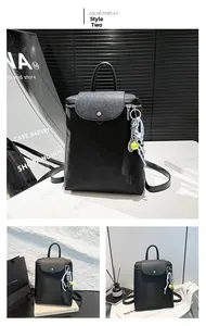 Detail view of a black minimalist backpack with nylon texture and tennis charm
