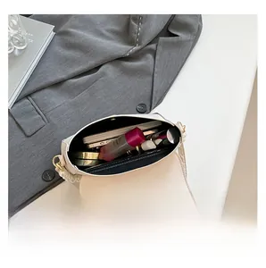 Detail view of the interior capacity and elegant pearl strap on the beige underarm bag