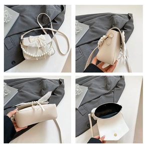 Detail view of cream leather shoulder bag with mesh bow and faux pearl chain strap