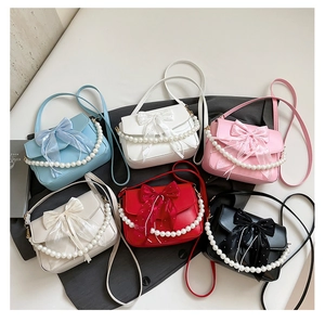 Flat lay of bow-knot crossbody bags in six colors with decorative pearl handles