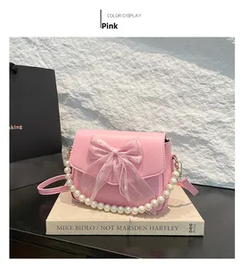 Pink mini crossbody bag with a sequined tulle bow and elegant pearl handle detail