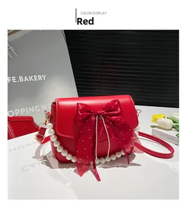 Detail of red bow purse with pearl chain and elegant PU leather texture for women